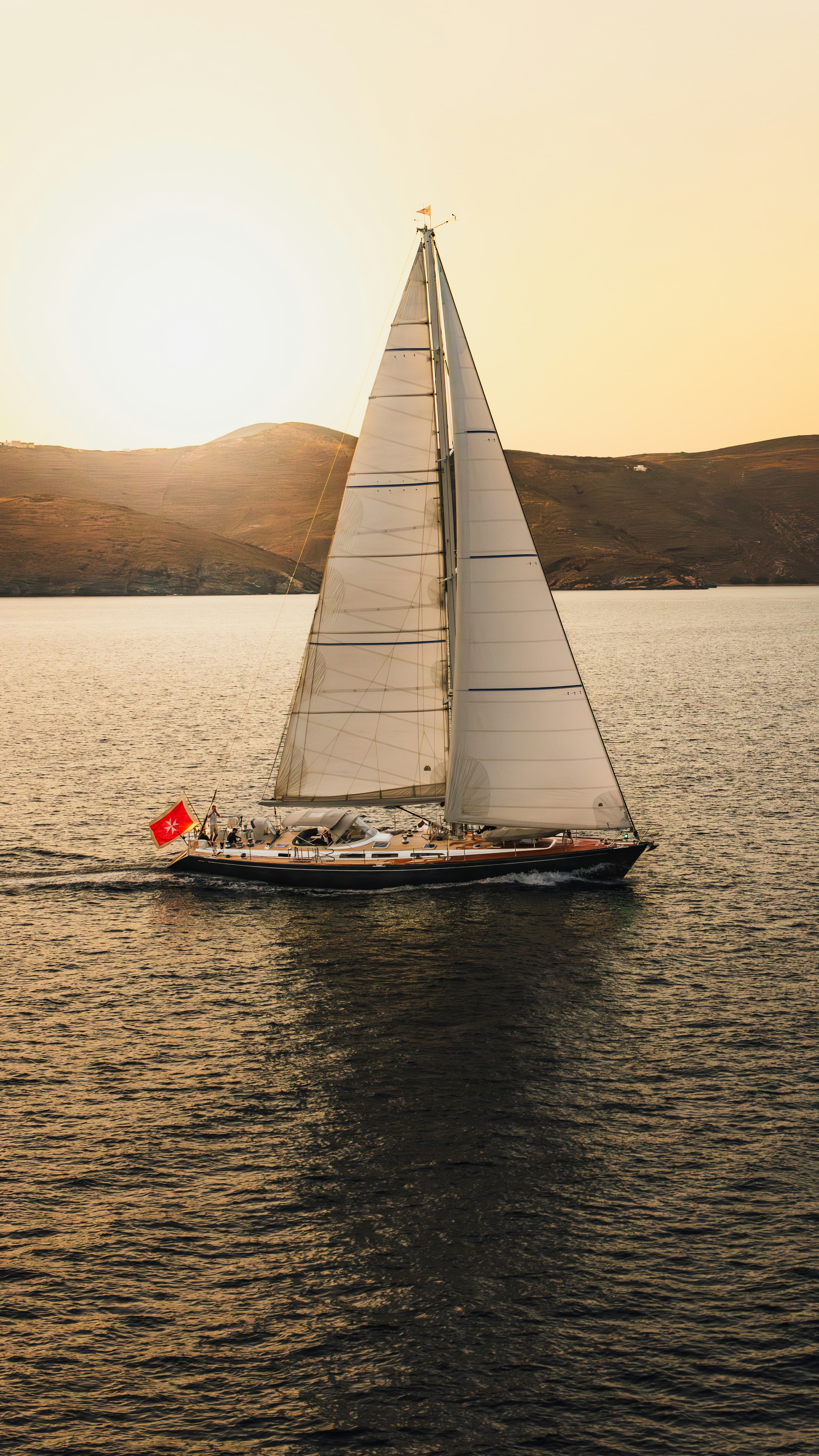 A sailing yacht under way at sunset